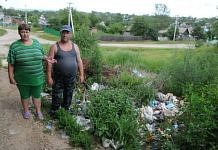 В северном микрорайоне Свободного размытую после наводнения дорогу завалили мусором